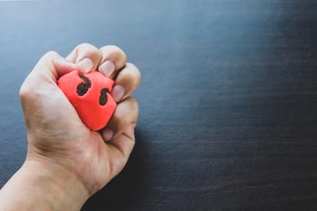 Hand squeezes a stress ball in anger and frustration 