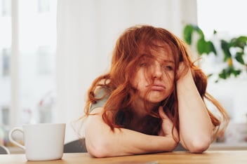 Frazzled, stressed out woman looks frustrated and defeated