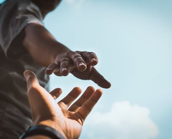 Hand reaching down to help pull someone up