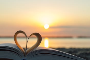 Book pages making a heart at sunset 